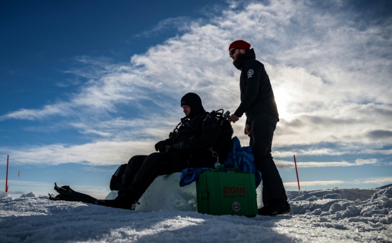 Erik Wurz, plongeur-chercheur, Erik Wurz (D), derrière un plongeur lors d'un stage scientifique de plongée polaire, le 14 mars 2026 sur le lac de Kilpisjärvi, à l'extrême nord-ouest de la Finlande