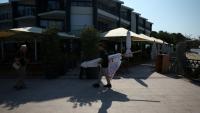 Un employé de restaurant transporte un parasol à Andernos-les-Bains, en Gironde, le 1er août 2026
