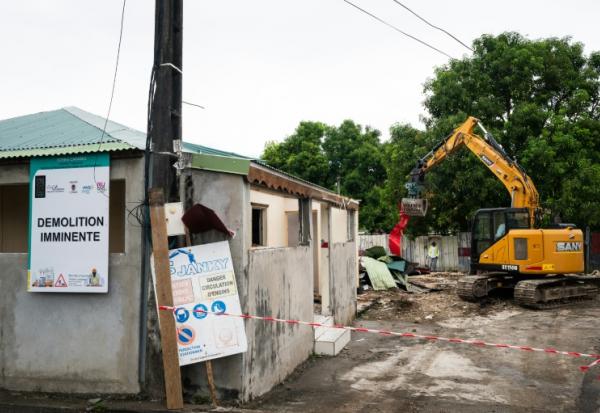 Un engin démantèle un bâtiment dans un quartier des Abymes en Guadeloupe qui doit être reconstruit, le 9 avril 2025