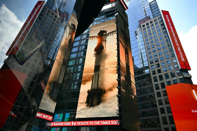 Images géantes de fusées SpaceX sur les murs d'immeubles de Times Square, à New York, non loin de celui du Nasdaq, le jour de l'entrée en Bourse, le 12 juin 2026. 