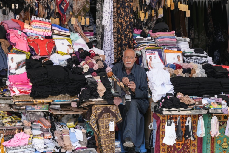 Un vendeur attend des clients dans sa boutique  à Najaf, qui abrite le sanctuaire de l'imam chiite Ali, le 22 avril 2026 en Irak