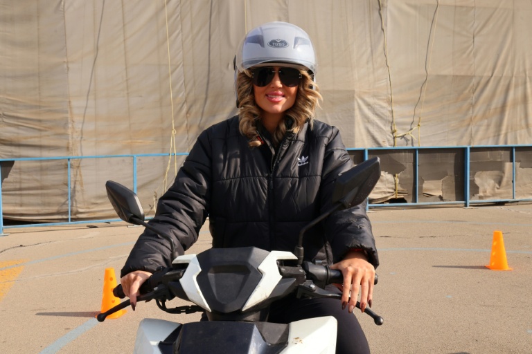 Mona apprend à conduire une moto dans un centre d'entraînement du nord de Téhéran, le 7 décembre 2025 en Iran