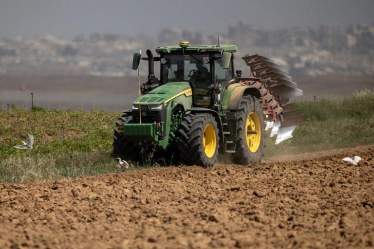 Un agriculteur en tracteur dans un champ agricole près de la frontière entre le sud d'Israël et la bande de Gaza, le 21 mai 2025