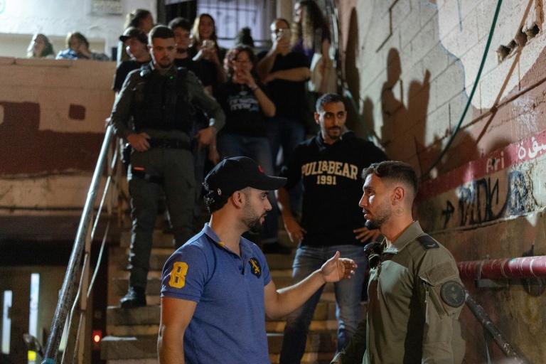 L'influenceur d'extrême droite Mordechai David discute avec des forces de sécurité lors déployés pour l'empêcher de bloquer l'entrée à une réunion d'une liste arabe pour les législatives, à Tel-Aviv le 5 octobre 2026