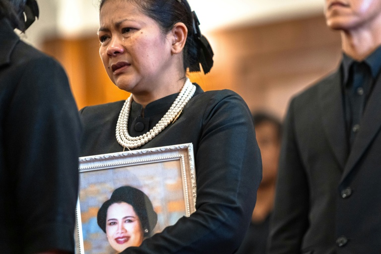 Une femme endeuillée pleure dans la queue pour rendre hommage à l'ancienne reine Sirikit de Thaïlande au Grand Palais de Bangkok, le 26 octobre 2025