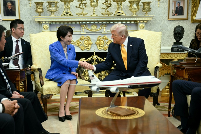 Le président américain Donald Trump serre la main de la Première ministre japonaise Sanae Takaichi lors d'une rencontre dans le Bureau ovale de la Maison Blanche, le 19 mars 2026 à Washington