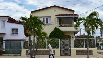 Un passant marche devant une maison dans un quartier cossu de La Havane, le 23 avril 2026