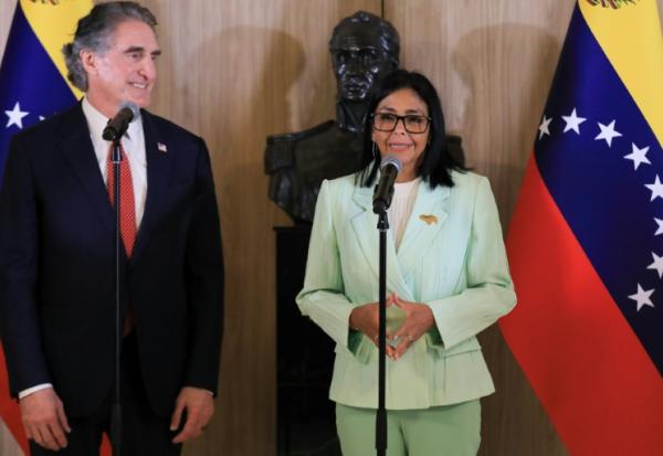 Photo diffusée par le bureau de presse de la présidence vénézuélienne montrant la présidente par intérim du Venezuela, Delcy Rodriguez (d), signant un document aux côtés du ministre américain à l'Intérieur, Doug Burgum, au palais présidentiel de Miraflores, le 5 mars 2026 à Caracas