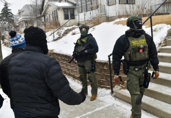 Des agents fédéraux face à des civils le 16 janvier 2026 à Saint Paul, dans le Minnesota