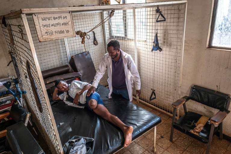 Belete Melke (g), 25 ans, blessée à la jambe par des tirs croisés, effectue des exercices de physiothérapie avec le technicien orthopédiste Bashawgize Getie au centre de rééducation physique de Bahir Dar, le 8 décembre 2025