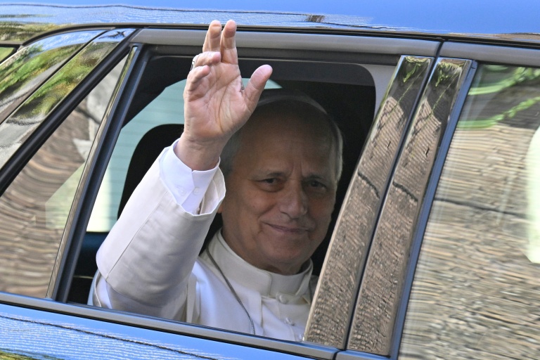 Le pape Léon XIV fait un salut par la fenêtre d'une voiture avant d'être admis à l'hôpital Gemelli à Rome, le 13 octobre 2026