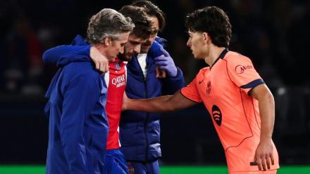 L'attaquant du PSG Khvicha Kvaratskhelia (c) quitte la pelouse après s'être blessé au genou droit lors du match contre le FC Barcelone, réconforté par Xavi Espart, le 20 octobre 2026 au Parc des Princes