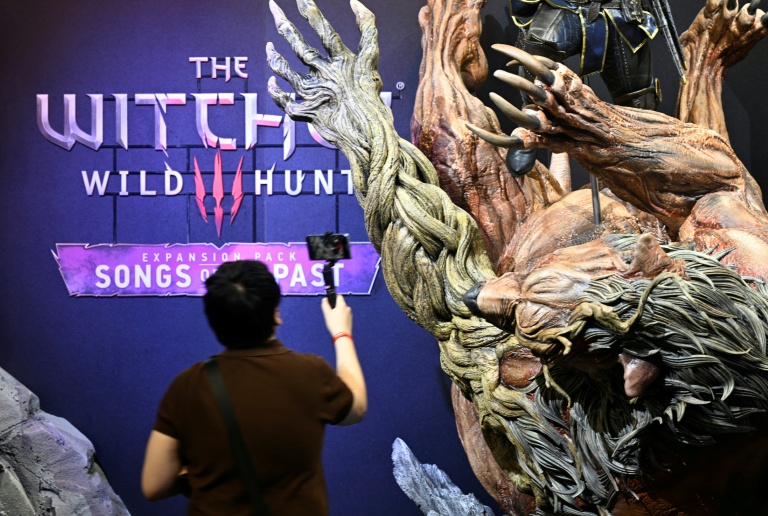 Un visiteur prend des photos sur le stand consacré au jeu vidéo 