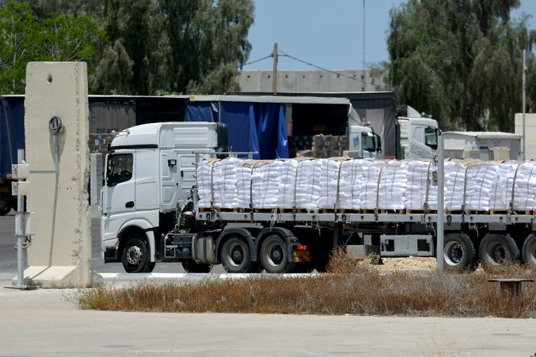 Un camion transportant de l'aide entre dans la bande de Gaza depuis le point de passage israélien de Kerem Shalom, le 20 mai 2025, sur fond de guerre Israël et le mouvement palestinien armé Hamas