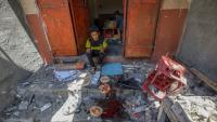 Des enfants palestiniens récupèrent du pain dans une boulangerie détruite par des frappes israéliennes dans le camp de réfugiés de Nousseirat, dans le centre de la bande de Gaza, le 8 mai 2025