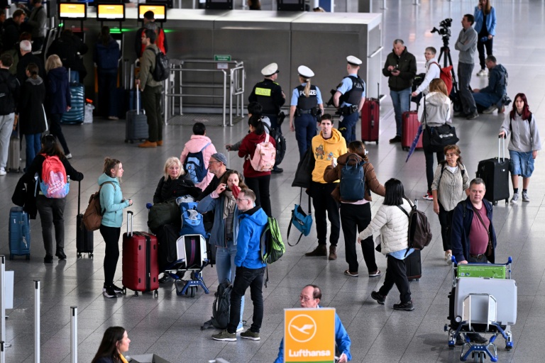 Des passagers attendent près d'un comptoir de la compagnie aérienne à l'aéroport de Francfort, alors qu'une grande partie des vols sont annulés pour cause de grève le 12 mars 2026