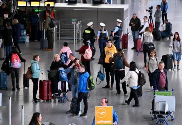 Des passagers attendent près d'un comptoir de la compagnie aérienne à l'aéroport de Francfort, alors qu'une grande partie des vols sont annulés pour cause de grève le 12 mars 2026