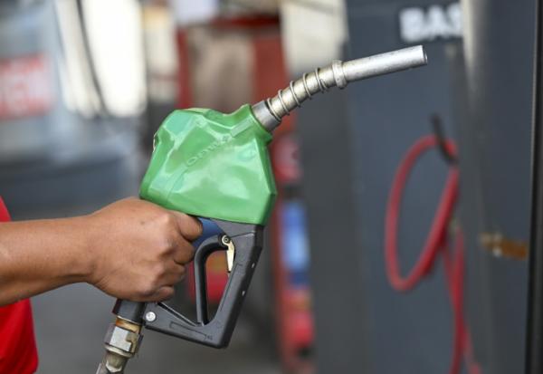 Un automobiliste se sert en carburant dans une station-service à Guatemala City, le 19 mars 202+