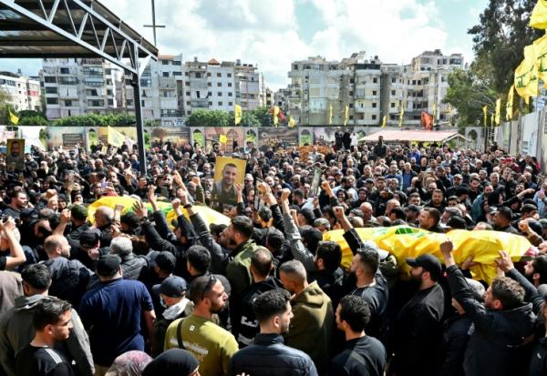 Des personnes en deuil portent les cercueils recouverts de drapeaux de membres du groupe militant Hezbollah soutenu par l’Iran, tués dans le sud du Liban, lors de leurs funérailles dans le quartier de Kafaat, dans la banlieue sud de Beyrouth, le 20 avril 2026