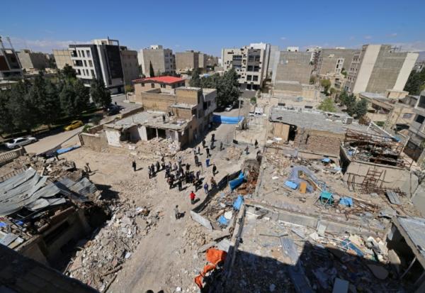 Des représentants des médias se rassemblent autour d'immeubles résidentiels endommagés par des frappes récentes dans la ville de Vahdat, au sud-ouest de Téhéran (Iran), le 3 avril 2026