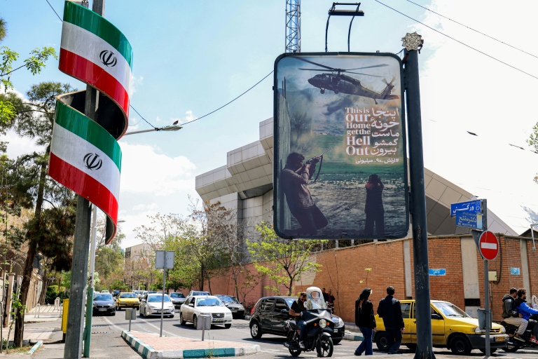 Une affiche anti-américaine représentant un hélicoptère sous le feu ennemi dans une rue de Téhéran, le 6 avril 2026 en Iran