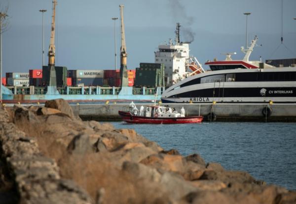 Un bateau-ambulance transportant des membres d'équipage en combinaisons de protection  retourne au port de Praia, après une visite à bord du bateau de croisière MV Hondius, au mouillage au large du port, le 5 mai 2026 au Cap-Vert