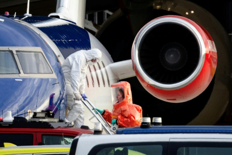 Une personne en combinaison blanche débarque le 6 mai 2026 d'un avion médicalisé Bombardier Challenger 605 censé transporter des passagers du bateau de croisière MV Hondius touché par une épidémie d'hantavirus
