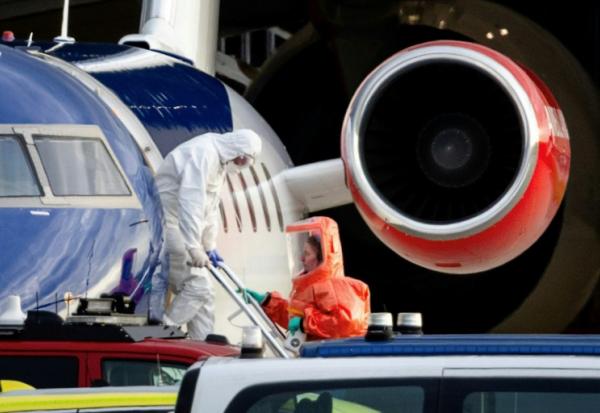 Une personne en combinaison blanche débarque le 6 mai 2026 d'un avion médicalisé Bombardier Challenger 605 censé transporter des passagers du bateau de croisière MV Hondius touché par une épidémie d'hantavirus