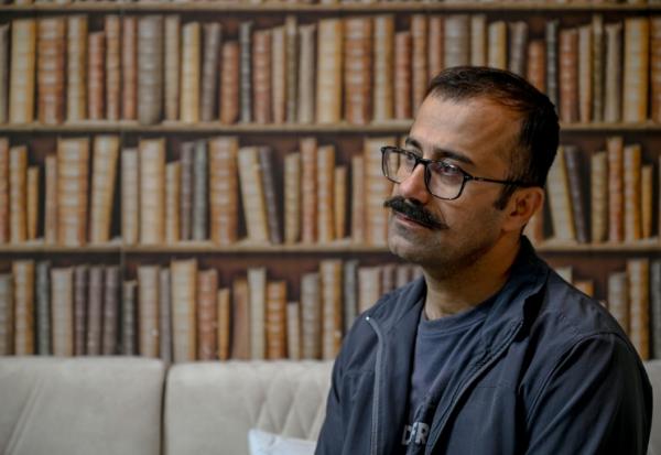 Farhad Sheikhi, un Kurde iranien qui a rejoint les manifestations antigouvernementales en 2022, montre des images des manifestations en Iran lors d'une interview à Souleimaniyeh, le 12 mars 2026 en Irak