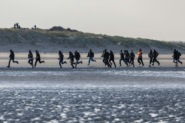 Des migrants courent pour embarquer sur un bateau de passeurs et tenter de traverser la Manche au large de la plage de Gravelines, dans le Nord, le 3 mars 2026
