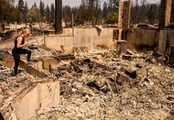 Kimber Renz regarde les ruines de sa maison détruite par les flammes à Spokane, dans l'Etat de Washington, le 4 août 2026