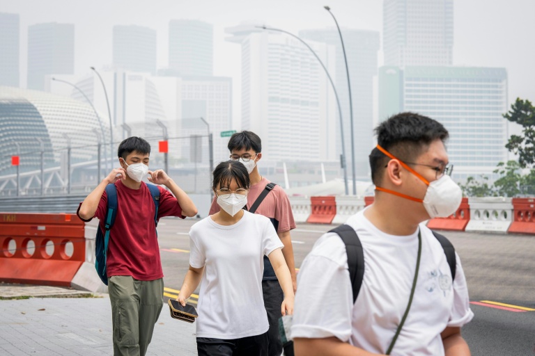 Des passants équipés de masques dans une rue de Singapour le 16 octobre 2026