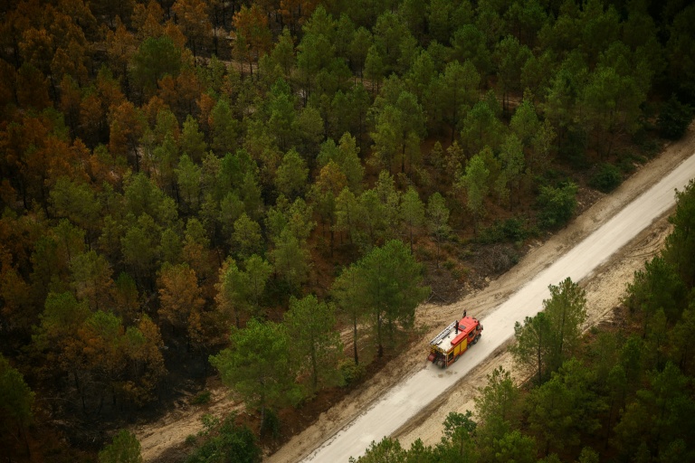 Vue aérienne depuis un hélicoptère de la sécurité civile montrant un camion de pompiers sur une route à Le Porge, en Gironde, le 31 juillet 2026
