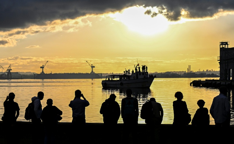 Des habitants regardent le bateau Maguro du convoi international 