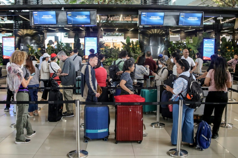 Des passagers bloqués à l'aéroport Soekarno-Hatta de Tangerang font la queue pour demander le remboursement de leurs billets après l'annulation de vols réguliers due à l'éruption du volcan Anak Krakatoa, le 6 septembre 2026 en Indonésie
