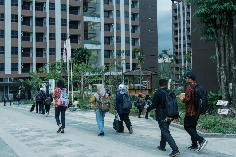 Des fonctionnaires se dirigent vers leurs appartements après leur arrivée en navette à Ibu Kota Nusantara (IKN), la nouvelle capitale prévue de l'Indonésie, le 15 août 2025