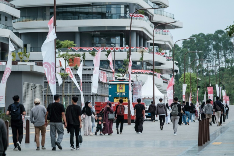 Des touristes et fonctionnaires dans une rue à Ibu Kota Nusantara (IKN), la nouvelle capitale prévue de l'Indonésie, le 15 août 2025