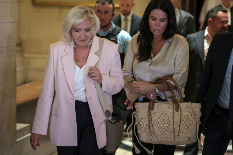 Marine Le Pen, présidente du groupe parlementaire du Rassemblement national (g), accompagnée de la députée européenne Catherine Griset (d), quitte la cour d'appel de Paris le 7 juillet 2026, après le prononcé de l'arrêt en appel pour détournement de fonds publics européens dans l'affaire des emplois présumés fictifs au Parlement européen