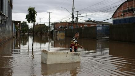 Un habitant utilise un réfrigérateur endommagé comme embarcation pour transporter des provisions dans une rue inondée de Porto Alegre, dans l'État de Rio Grande do Sul, au Brésil, le 26 mai 2024, pendant des inondations historiques dans le pays