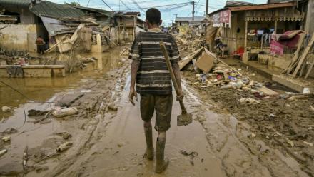 Un homme marche dans une rue couverte de boue après une crue soudaine qui a frappé la région d'Aceh Tamiang, dans la province d'Aceh, sur l'île indonésienne de Sumatra, le 6 décembre 2025