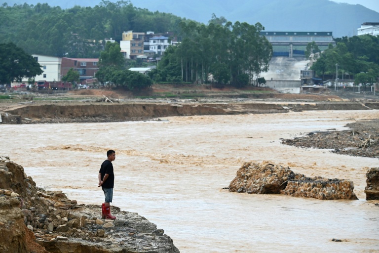 Un homme regarde l’eau s’écouler du réservoir effondré de Liulan, dans le village de Liulan, dans la ville de Hengzhou, dans la région du Guangxi, au sud-ouest de la Chine, le 8 juillet 2026