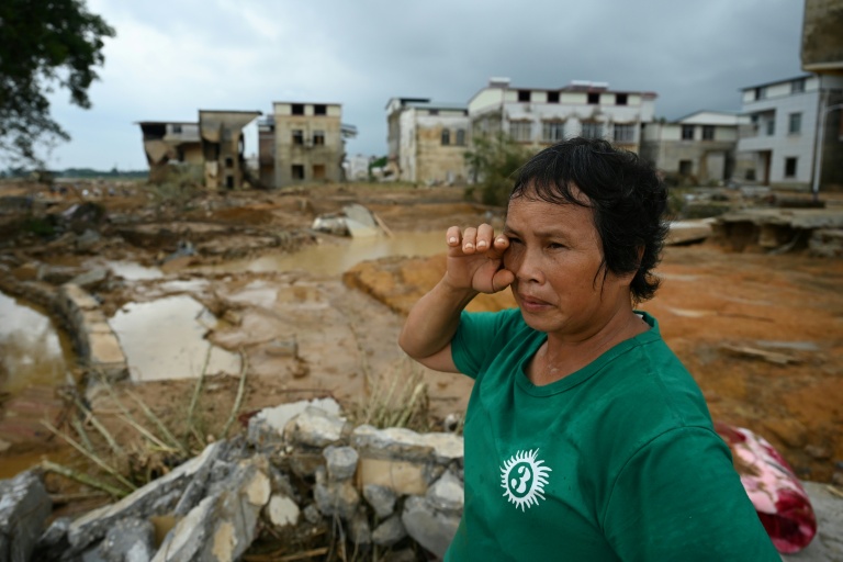 Une femme examine les dégâts dans le village de Liulan, inondé lorsqu'un réservoir s’est effondré dans la ville de Hengzhou, dans la région du Guangxi, au sud-ouest de la Chine, le 8 juillet 2026