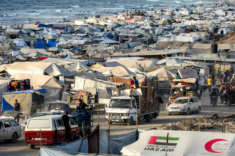 Des véhicules passent devant des tentes dressées le long du front de mer de la ville de Gaza, dans le nord de la bande de Gaza, alors des habitants fuient vers le sud, le 2 septembre 2025