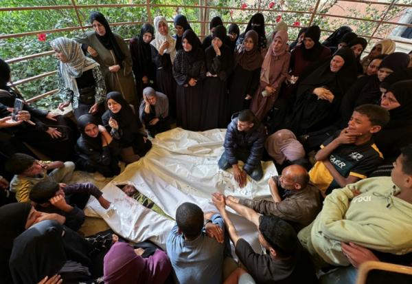 Des Palestiniens pleurent devant les corps de roches tués lors de frappes israéliennes sur des tentes de déplacés dans la zone d'al-Mawassi dans le sud de Gaza, à l'hôpital Nasser de Khan Younès, le 18 mai 2025