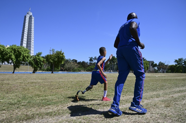 Juan José Guilarte, 10 ans, court avec son entraîneur, Albert Luis Campbell, pendant une session de pentathlon à La Havane, le 16 avril 2026 à Cuba