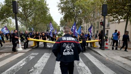 Un pompier portant une inscription "En grève" participe à une manifestation organisée par une large coalition de syndicats, à Paris, le 28 septembre 2026