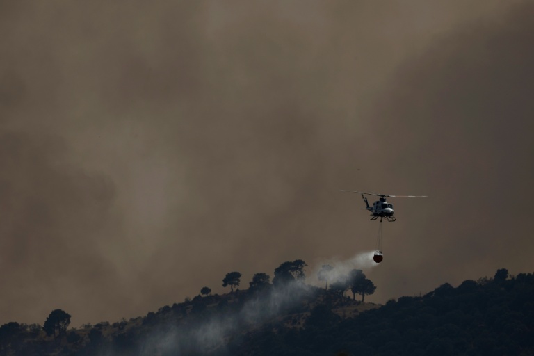 Un hélicoptère bombardier d’eau largue de l’eau sur un incendie de forêt près de Robledo de Chavela, à environ 60 kilomètres à l’ouest de Madrid, le 27 juillet 2026