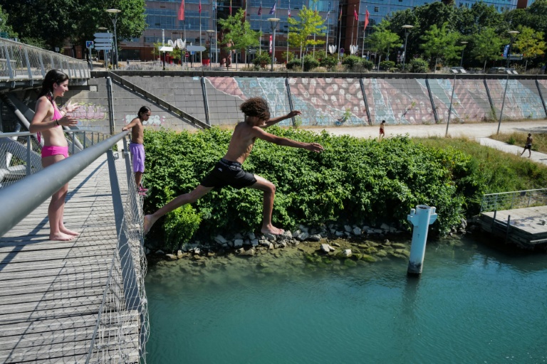 Un groupe d'adolescents saute  dans le Rhône depuis la Passerelle de la Paix à Lyon, le 25 juin 2026
