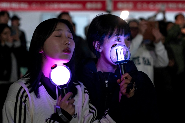 Des fans regardent le concert marquant le retour du groupe de K-pop BTS sur un écran installé à Séoul, le 21 mars 2026