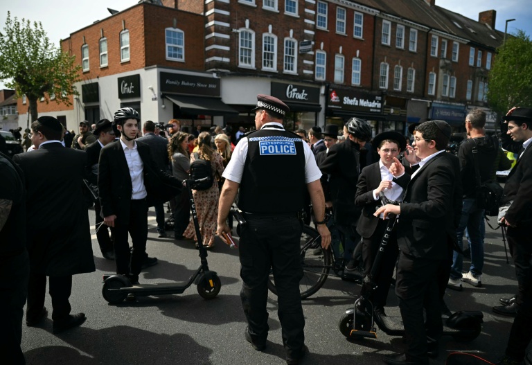 Un officier de la Metropolitan Police demande à des membres de la communauté juive de s'éloigner d'un cordon à l'angle de Golders Green Road et Beverley Gardens, dans le quartier de Golders Green, au nord de Londres, le 29 avril 2026